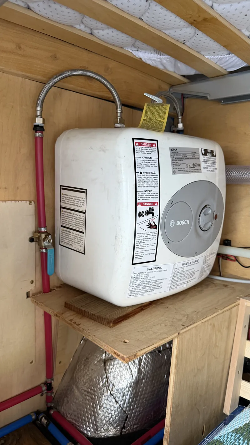 Electric water heater installed beneath the bed