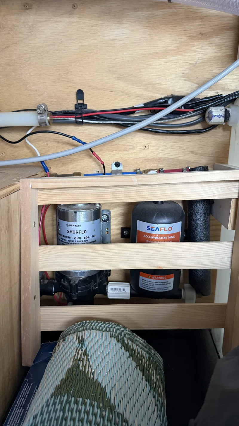 Water pump and plumbing behind the storage framing