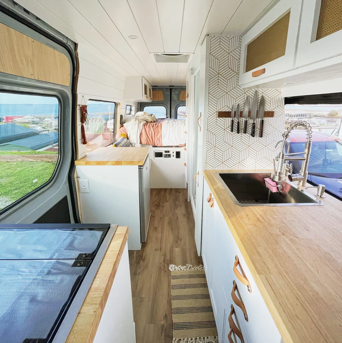 Full view of the kitchen with sink, oven, and wood countertops