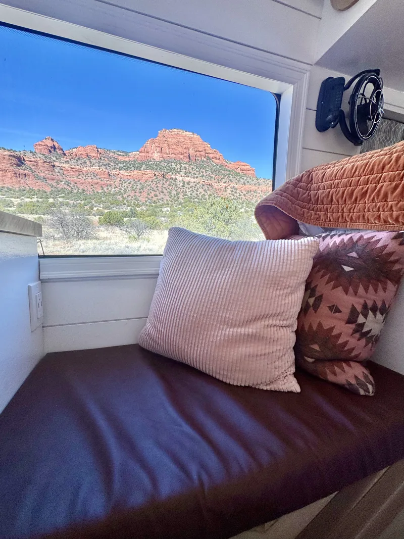 Bench seat with pillows beside a red rock view