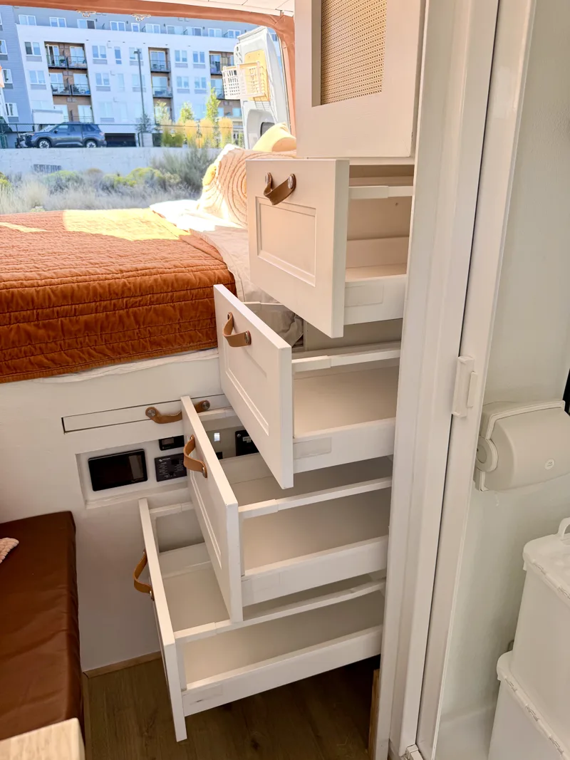 Four clothing drawers pulled open beside the bed
