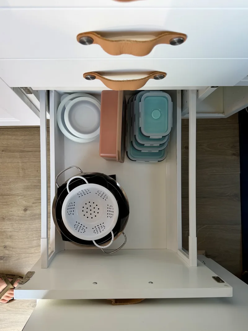 Open kitchen drawer holding dishes and food containers