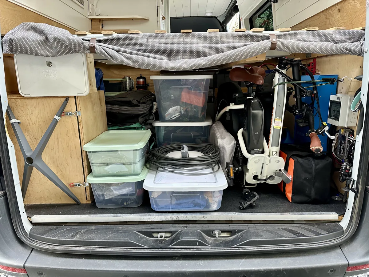 Rear storage area packed with bins and outdoor gear
